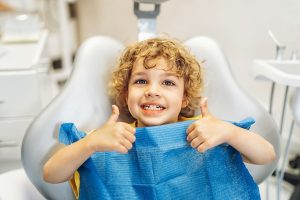 Child thumbs up first dental braces appointment